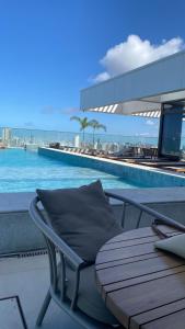 a chair sitting next to a pool on a building at Studio beach class Meireles in Fortaleza
