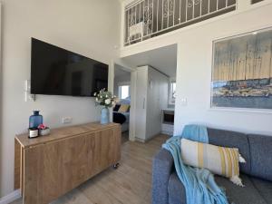 a living room with a couch and a flat screen tv at Time Out in Pohara in Pohara