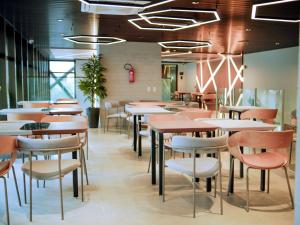 a restaurant with tables and chairs in a room at Studio beach class Meireles in Fortaleza