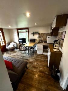 a kitchen and living room with a couch and a table at Cabaña en el bosque, Valdivia in Valdivia