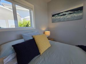 a bedroom with a bed with two pillows and a window at Time Out in Pohara in Pohara