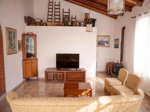 a living room with a couch and a television at Spacious villa with a large veranda and pool in Floridia