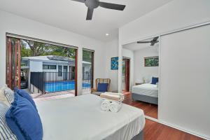 een slaapkamer met een bed en een groot raam bij Onda Beach Clifton Beach in Clifton Beach