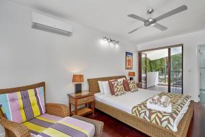 een slaapkamer met een bed en een stoel bij Onda Beach Clifton Beach in Clifton Beach +31 foto's