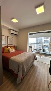 um quarto com uma cama grande e uma janela grande em Raízes Tucuruvi Studios em São Paulo