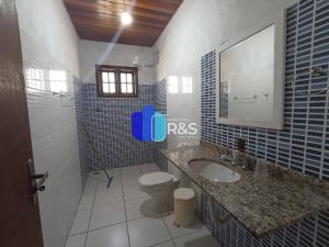 een badkamer met een wastafel, een toilet en een spiegel bij Chácara com 3 dormitórios in Louveira +8 foto's