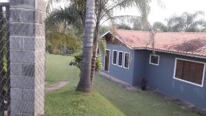 een blauw huis met een palmboom ervoor bij Chácara com 3 dormitórios in Louveira