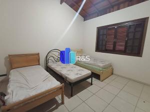 een kamer met 2 bedden en een raam met een raam bij Chácara com 3 dormitórios in Louveira