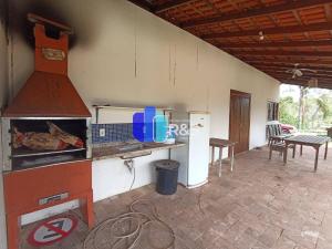 een keuken met een fornuis en een tafel met stoelen bij Chácara com 3 dormitórios in Louveira