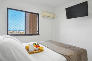 Studio no Porto das Dunas vista mar e Beach Park! في Mangabeira: غرفة بها سرير مع صينية طعام