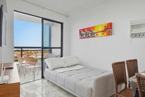 Studio no Porto das Dunas vista mar e Beach Park! في Mangabeira: غرفة معيشة مع أريكة وطاولة وكراسي