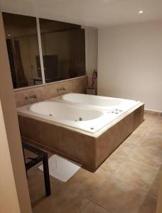 Mar de Ajó hostal في مار دي آخو: حوض استحمام كبير في الحمام مع مرآة