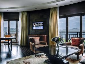 a living room with a table and chairs and windows at Rixos Borovoe in Borovoye