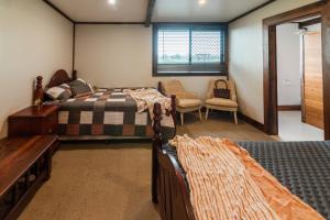 Bridge Moore Lodge في Bucca: غرفة نوم بها سريرين وكرسي