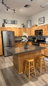 een keuken met een groot eiland met twee barkrukken bij Sunrise Ridge in Phoenix