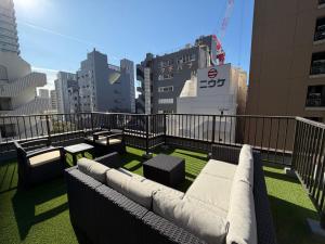 东京Plan A Tennozu Isle的阳台配有沙发和桌子,并拥有建筑