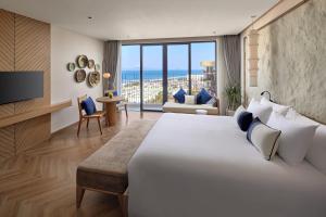 a bedroom with a large bed and a living room at Hoi An Royal Beachfront Resort & Villas in Dien Ban