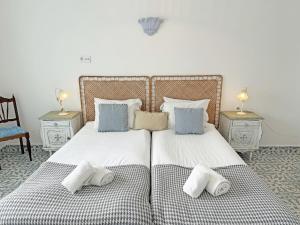 een slaapkamer met 2 bedden met kussens en 2 tafels bij Casa Florence - Fuseta in Fuzeta