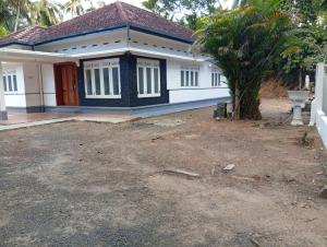 a small white house with a palm tree in front of it at Crystal Waters in Habaraduwa