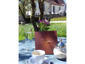 Mathilde Comfortable holiday residence في بوكِنغ: طاولة مع كوب من القهوة وكوب من الماء