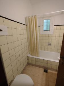 een badkamer met een bad, een toilet en een raam bij La caracola in Villa Gesell +19 foto's