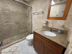 un bagno con wc, lavandino e doccia di Ocean View Apartment inside ESJ Hotel a San Juan