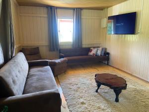 un soggiorno con un divano e un tavolo di Chácara Leopoldo Bairro a Lages 1 altra foto