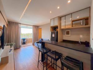 a kitchen and living room with a counter and chairs at Apto Luxo Gran Lençóis Atins 503 in Barreirinhas