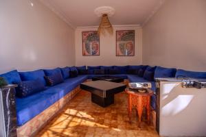 a blue couch in a living room with a table at Beachside Retreat in Imi ouadar in Agadir