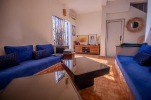 a living room with blue couches and a coffee table at Beachside Retreat in Imi ouadar in Agadir