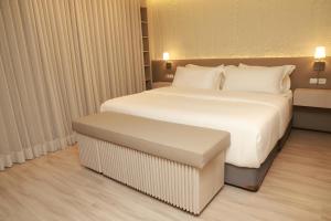 een slaapkamer met een groot wit bed en een bank. bij VPV Suites & Casino in Medellín +92 foto's