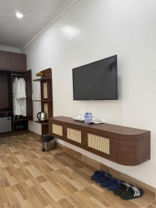 a living room with a flat screen tv on a wall at Avenue Hotel VangVieng in Vang Vieng