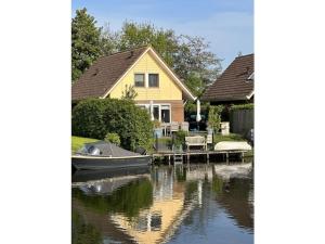 a house with a boat docked at a dock at Holiday home with 1 bedroom in Medemblik