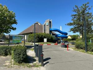 a playground with a blue slide in front of a building at Holiday home with 1 bedroom in Medemblik