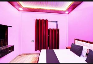 a bedroom with a bed with red drapes at Hotel Royal Vista in Meerut +3 photos