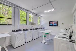 a white room with washing machines and a table at Palm Beach Condo 5 Mins to Beach Heated Pool in Palm Beach