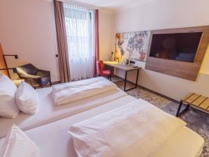 Una cama o camas en una habitación de Atomis Hotel Munich Airport by Mercure