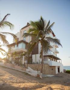 a building on the beach with a palm tree at Torre Marsai By MrW in Higuera Blanca