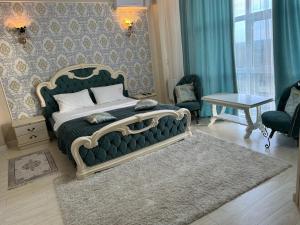 a bedroom with a large bed with a green couch at Diamond Hotel in Chişinău +16 photos