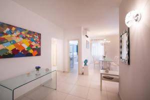un soggiorno con tavolo in vetro e un dipinto sulla parete di Al Corso Apartments by AMALFIVACATION a Minori