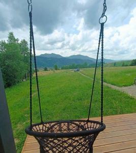 a basket hanging from a porch with a view of a field at Feeling Freedom in Tukhlya