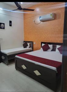 a bedroom with two beds and a ceiling fan at Ramam Hotel by Naavagat Near Ram Mandir in Ayodhya