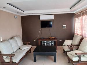 a living room with two couches and a tv at Aguaribay in Villa Los Aromos