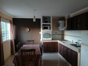 a small kitchen with a table and a microwave at Aguaribay in Villa Los Aromos +1 photo