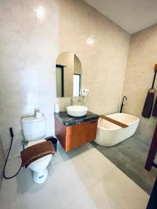 ウブドにあるDewangga Suiteのトイレ、洗面台、浴槽を備えたバスルーム +11枚の写真