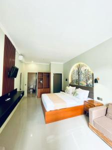 ウブドにあるDewangga Suiteの大きなベッドとソファのある広い寝室