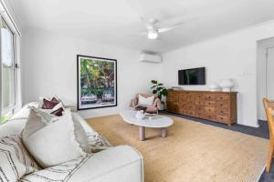 a living room with a couch and a table at The Little Husky by Experience Jervis Bay in Huskisson