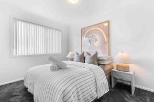 a bedroom with a bed with a laptop on it at The Little Husky by Experience Jervis Bay in Huskisson