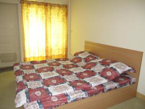 a bedroom with a bed with a quilt on it at The Prince Residence , Weekly Stay Chiang Rai in Chiang Rai +8 photos