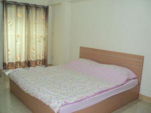 a bed with a wooden headboard in a bedroom at The Prince Residence , Weekly Stay Chiang Rai in Chiang Rai